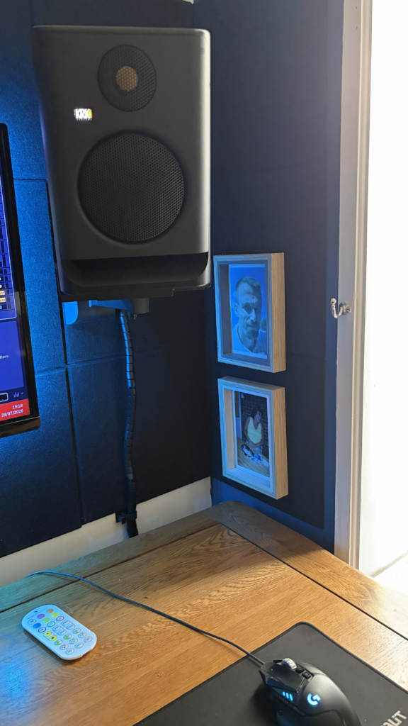 tudio desk corner with framed family photos, a speaker, gaming mouse